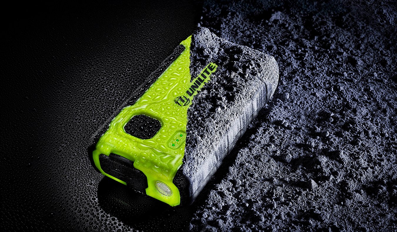 Unilite rechargeable LED work light with high-visibility green casing, shown in wet and rugged conditions for professional detailing and workshop use.