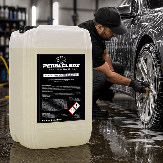 Person washing a car with PearlClenz acid alloy wheel cleaner in a garage setting.