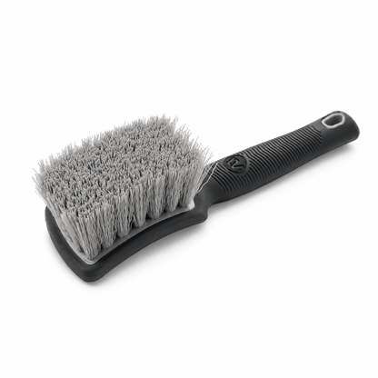 Grey tyre cleaning brush with a black ergonomic handle for car cleaning
