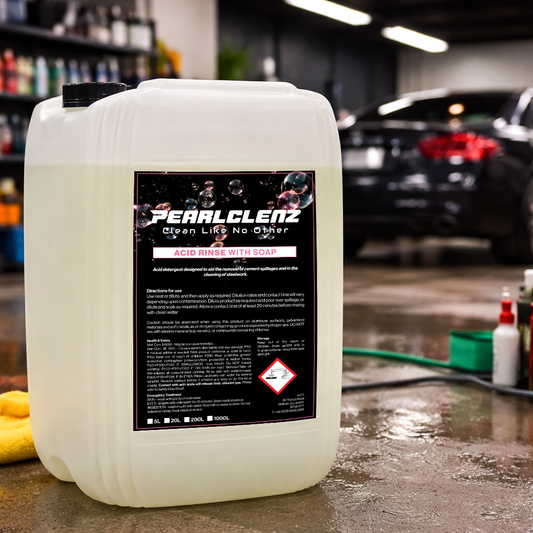 Pearlclenz Acid Rinse with Soap professional vehicle cleaning detergent, shown in a car detailing workshop with a freshly cleaned vehicle in the background.