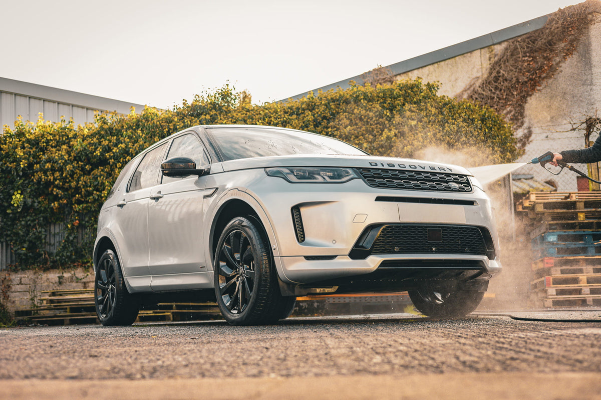 Land Rover Discovery Sport being pressure washed during a professional car detailing service. High-pressure rinse removes snow foam, road grime and traffic film, preparing the vehicle for a swirl-free wash and premium exterior car valeting