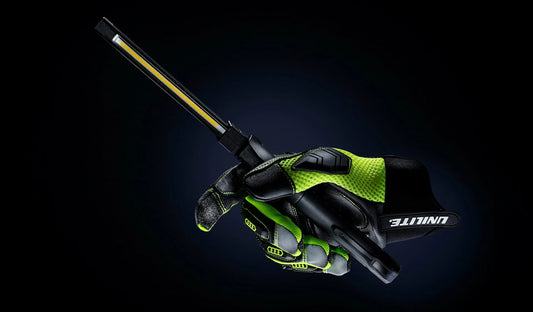 Unilite rechargeable LED inspection light held in a work glove for professional plumbing and electrical inspection.